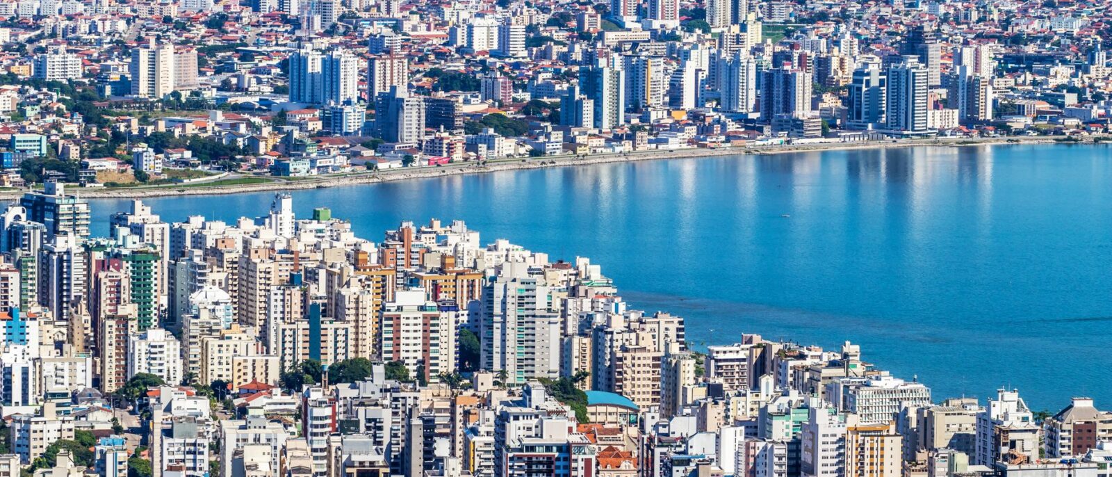 Vista aérea dinâmica de Florianópolis, Brasil, mostrando a orla urbana e paisagem urbana vibrante